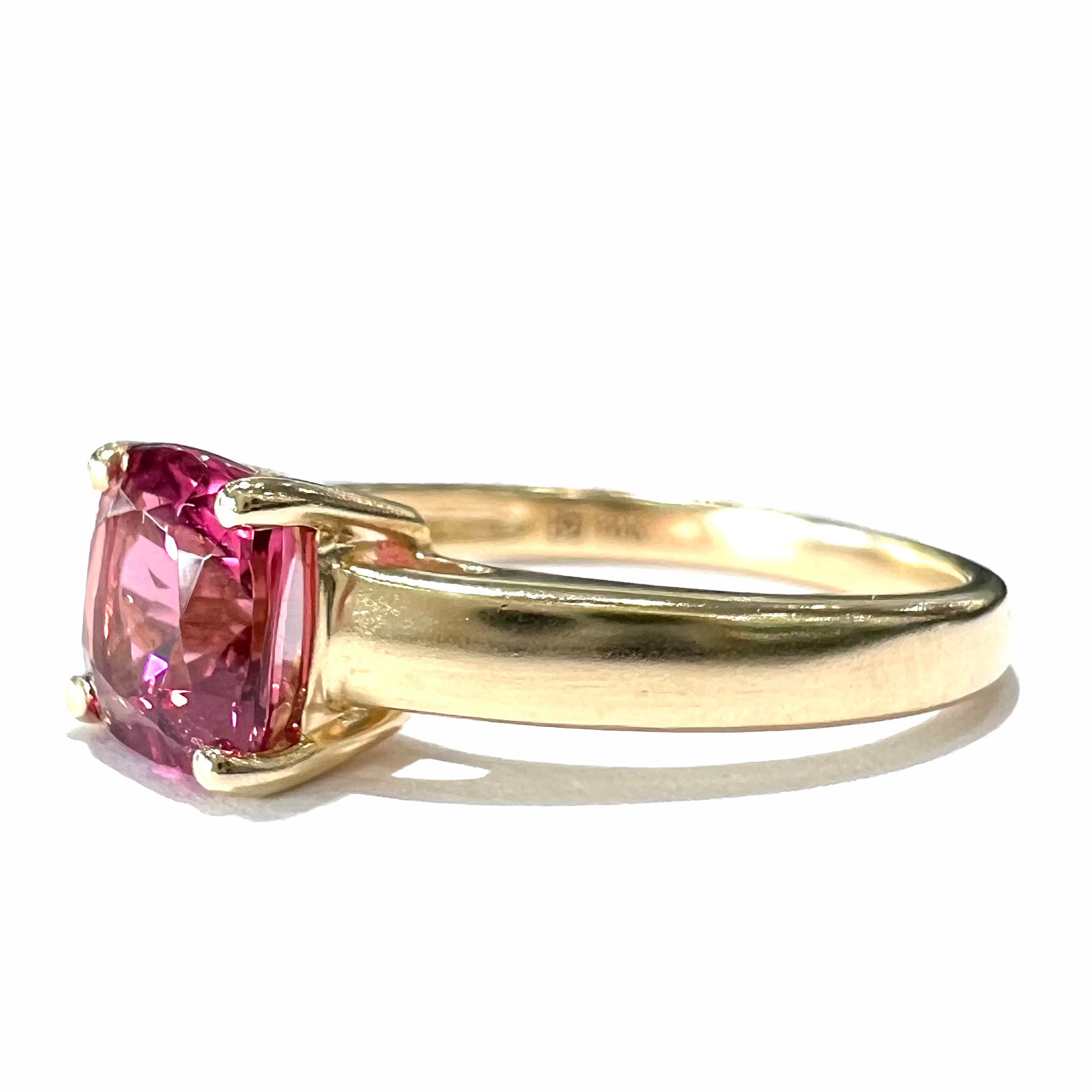 A ladies' cushion cut pink tourmaline solitaire ring in yellow gold.