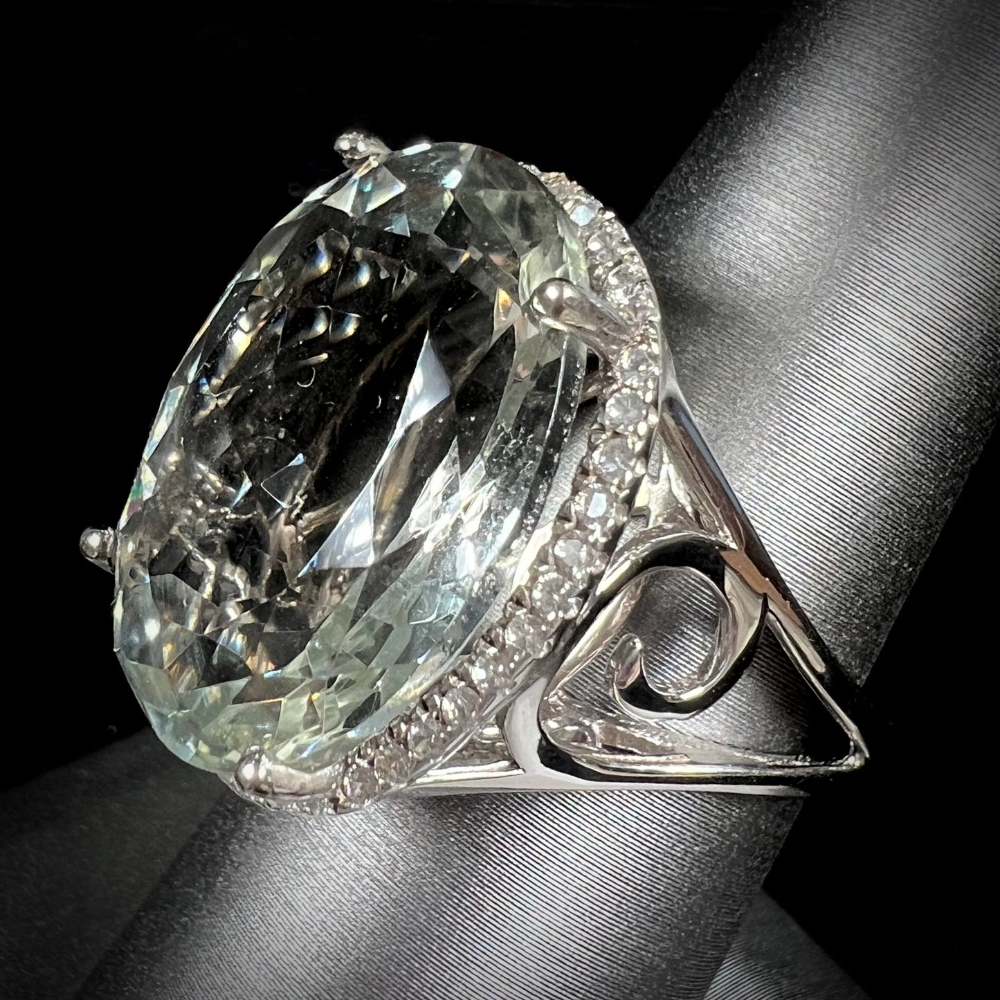 A ladies' green quartz and white zircon accented halo sterling silver cocktail ring.