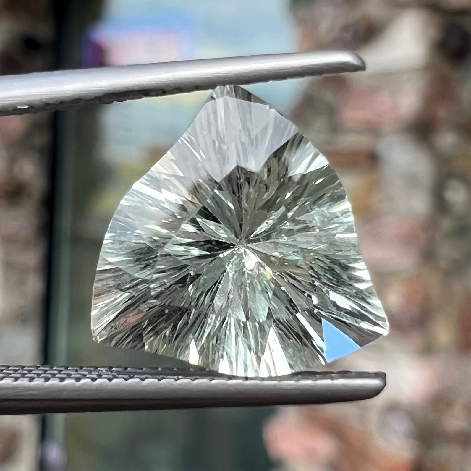 A loose, triangular fantasy cut prasiolite gemstone.  Prasiolite is a light green variety of quartz.