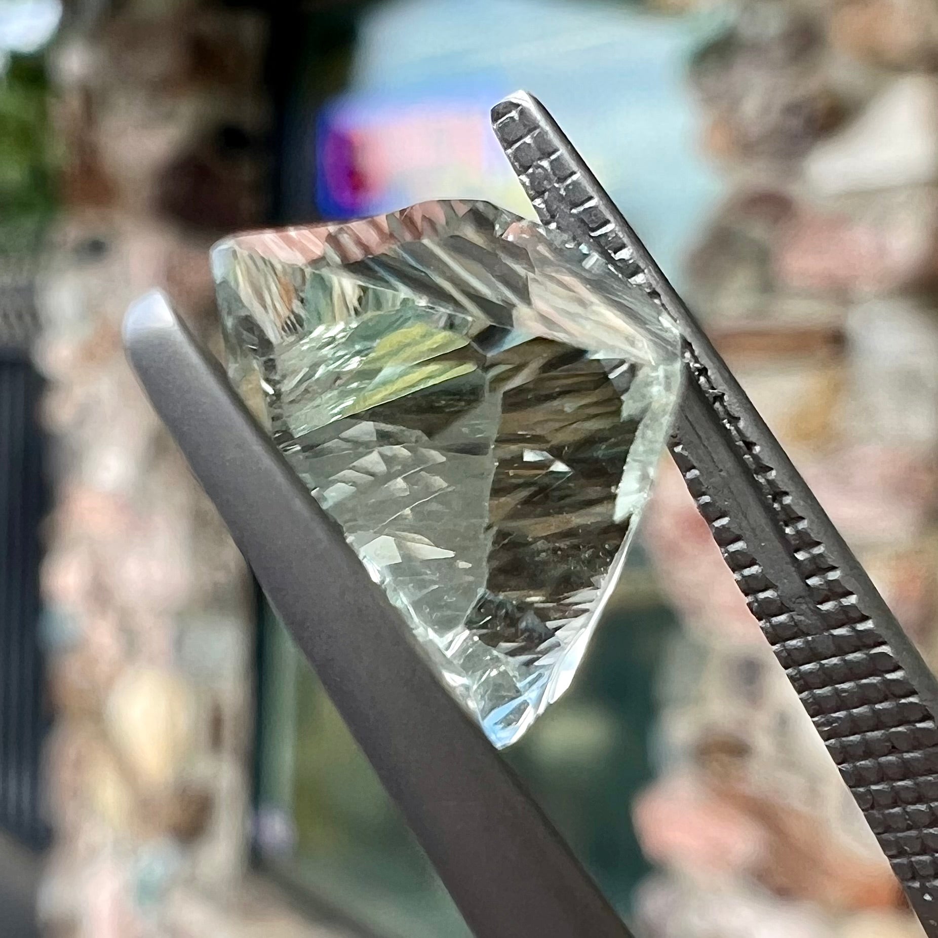 A loose, triangular fantasy cut prasiolite gemstone.  Prasiolite is a light green variety of quartz.