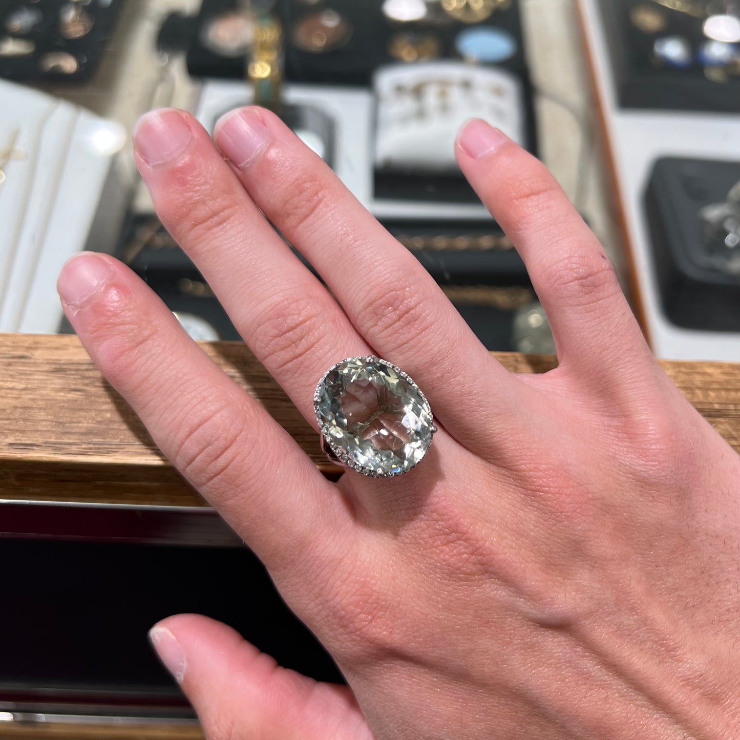 A ladies' green quartz and white zircon accented halo sterling silver cocktail ring.