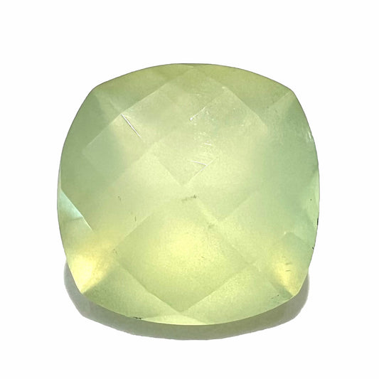 A loose, checkerboard cushion cut prehnite gemstone.  The stone is a sleepy yellow green color.