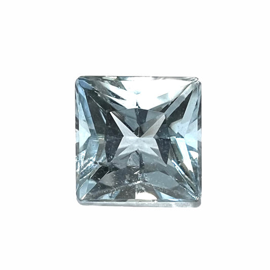 A loose, princess cut aquamarine gemstone.  The stone is a light blue color.