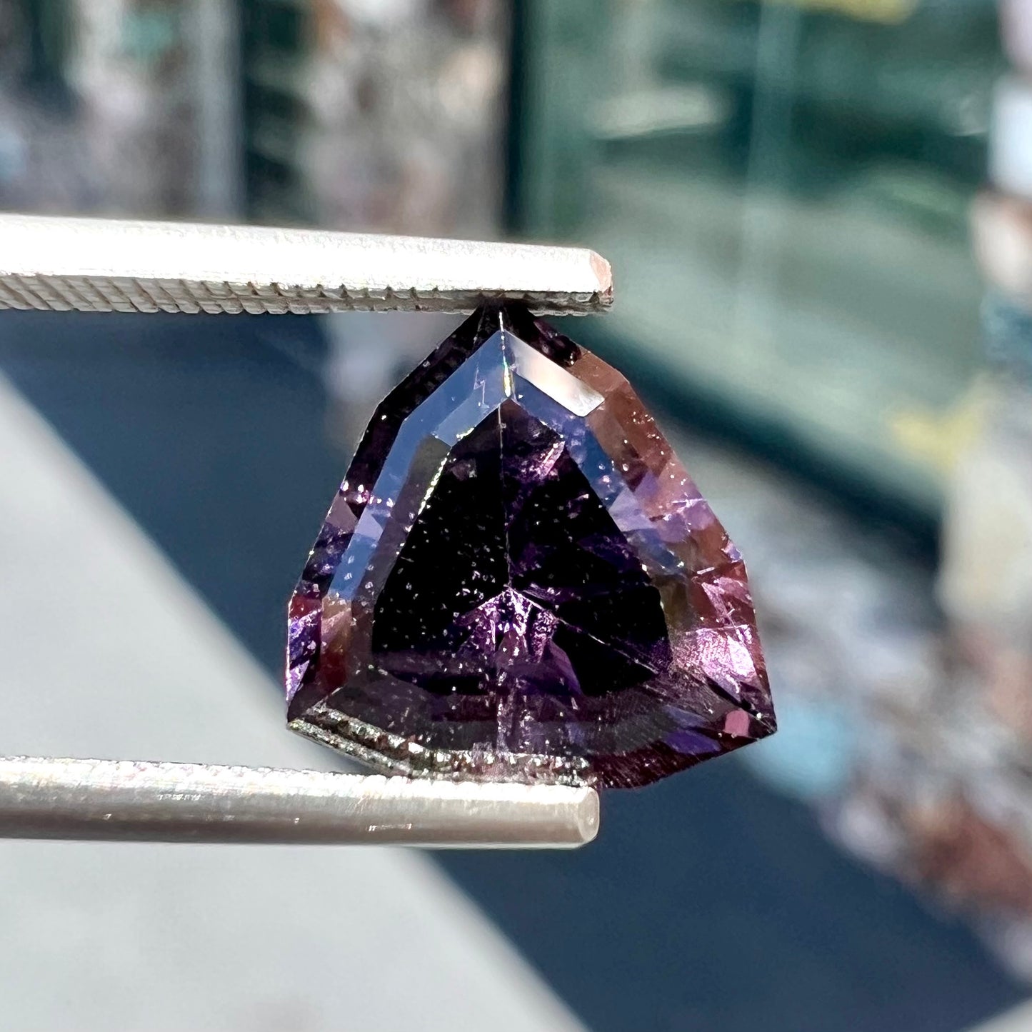 A loose, natural purple trillion cut spinel gemstone.