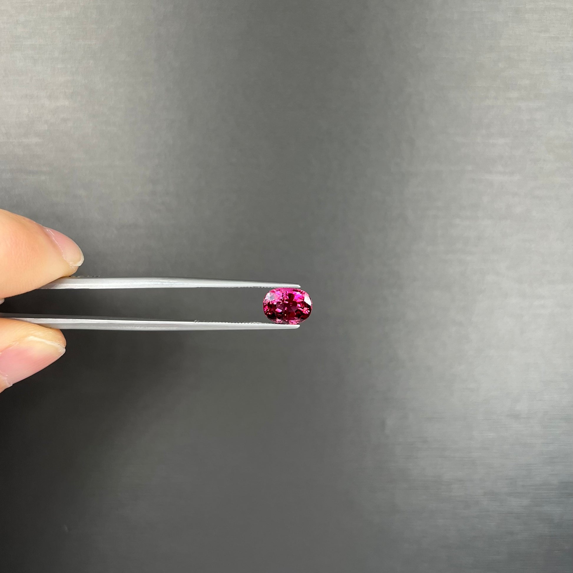 A loose, faceted oval cut purple tourmaline gemstone.  The stone weighs 2.08 carats.