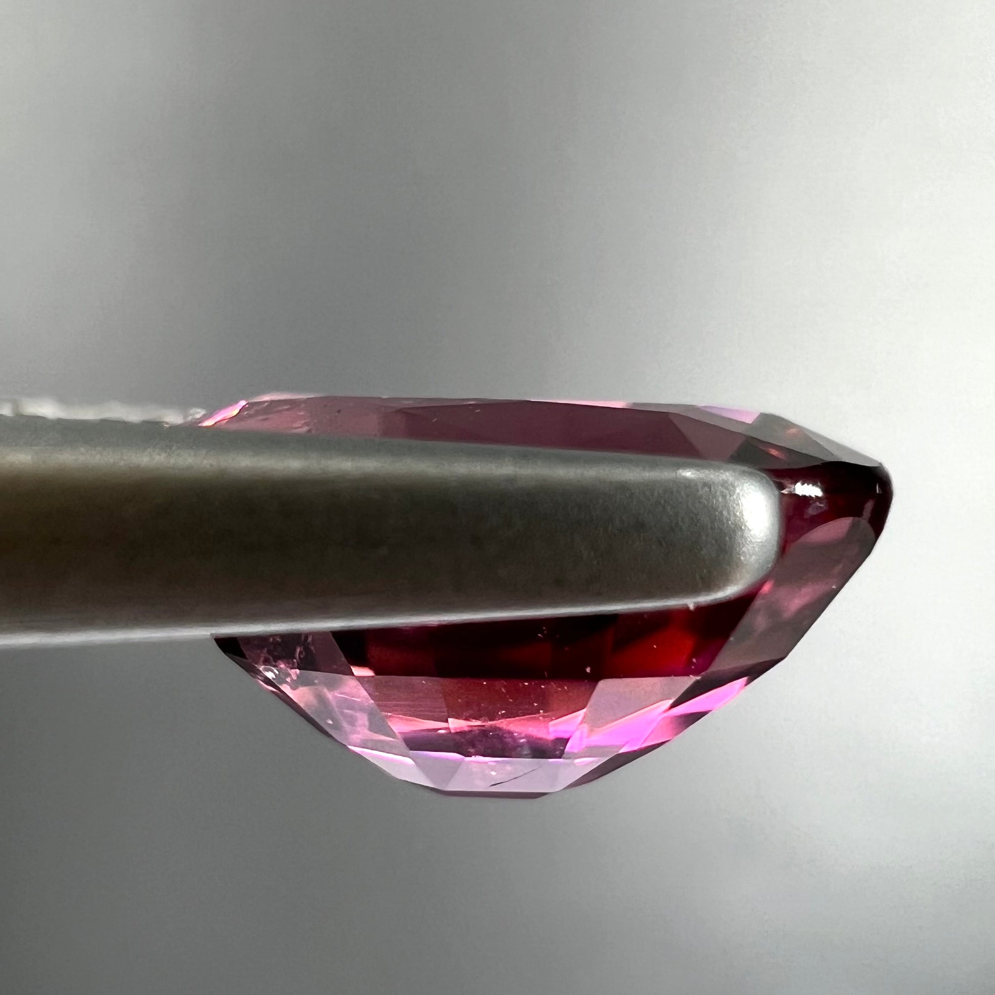 A loose, faceted oval cut purple tourmaline gemstone.  The stone weighs 2.08 carats.