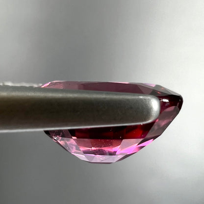 A loose, faceted oval cut purple tourmaline gemstone.  The stone weighs 2.08 carats.