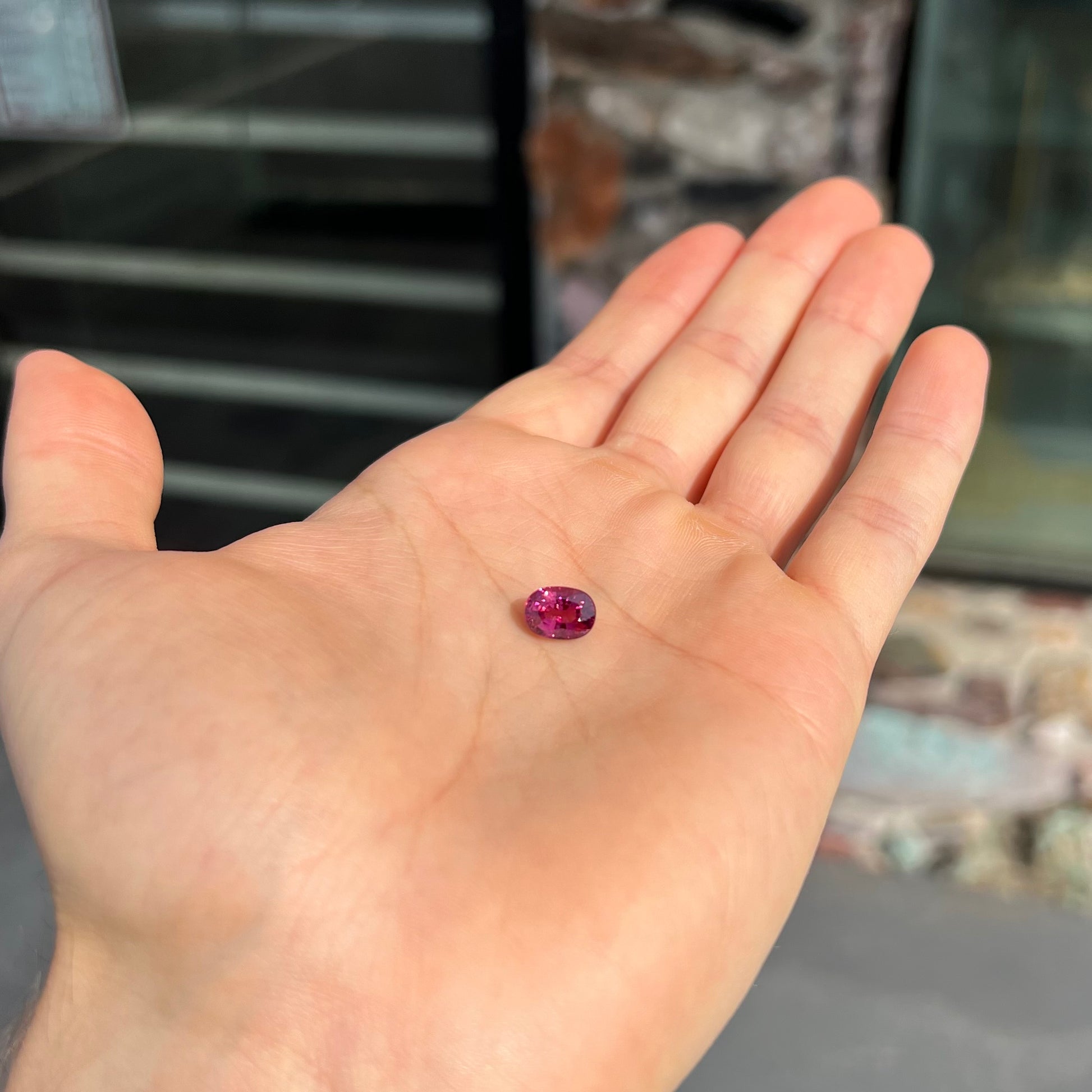 A loose, faceted oval cut purple tourmaline gemstone.  The stone weighs 2.08 carats.