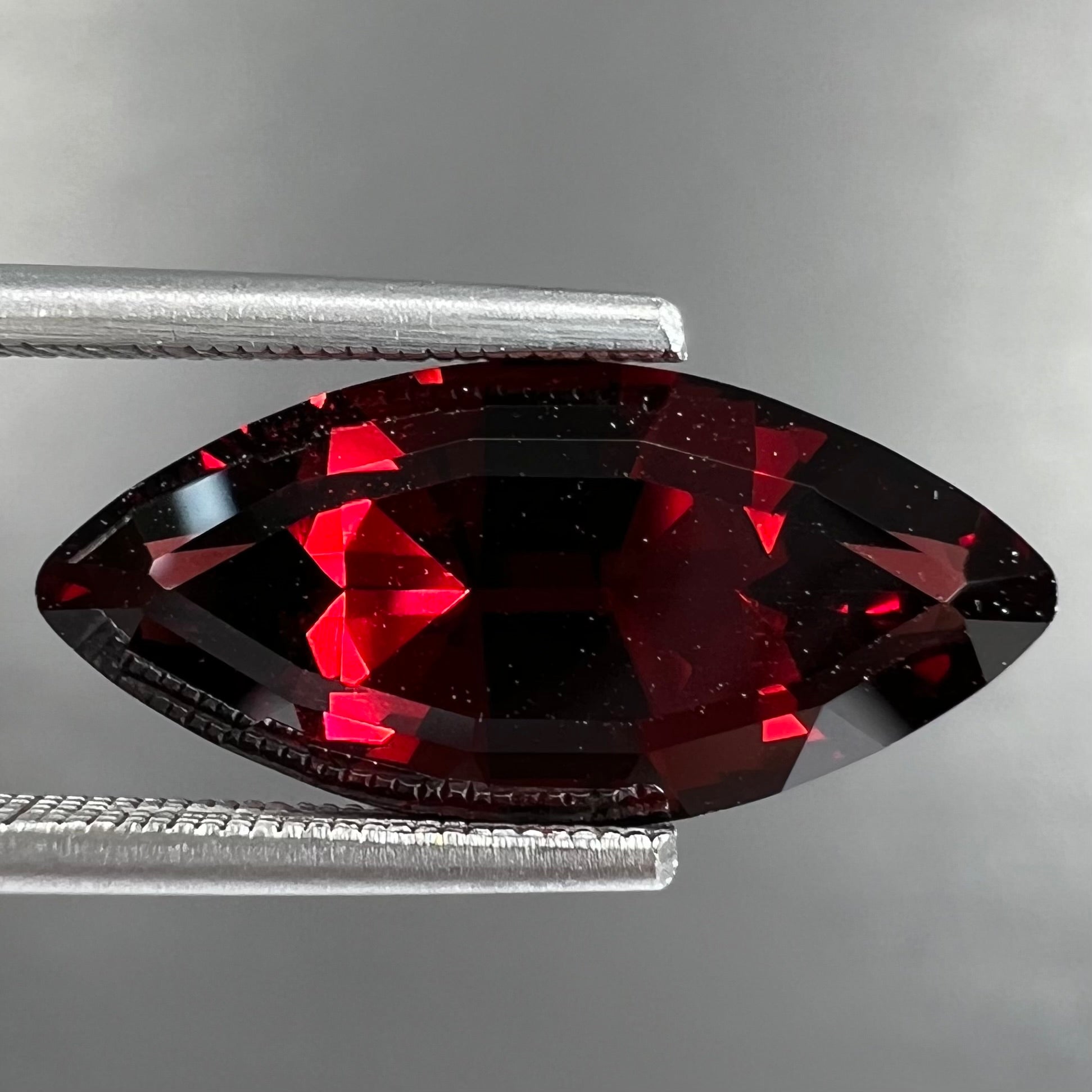 A faceted marquise cut red pyrope garnet stone.