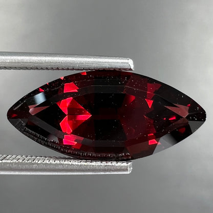 A faceted marquise cut red pyrope garnet stone.