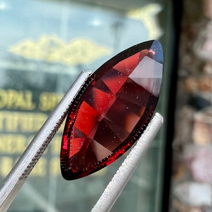 A faceted marquise cut red pyrope garnet stone.