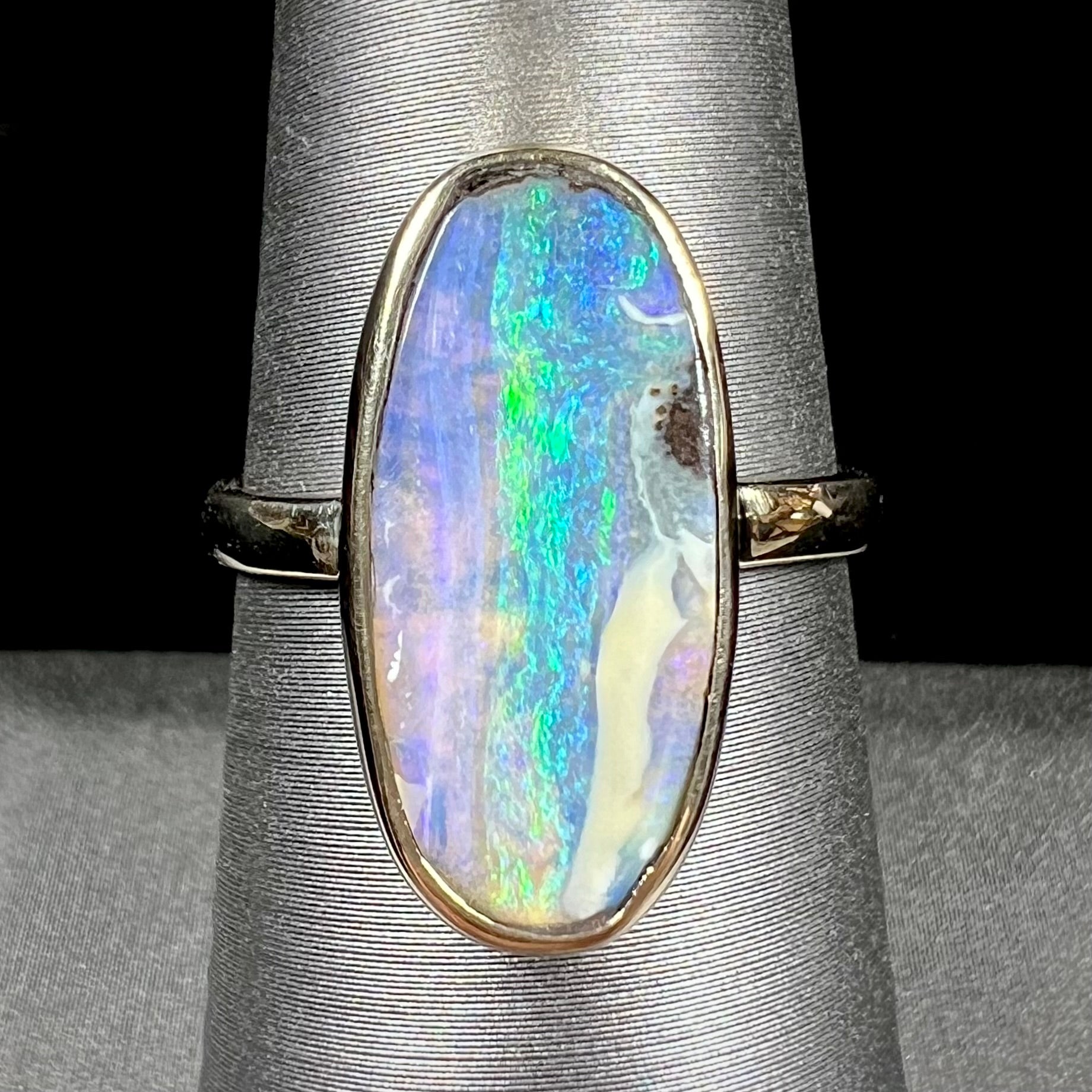 Ladies' yellow gold solitaire ring bezel set with a natural green striped boulder opal from Quilpie, Australia.