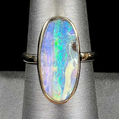 Ladies' yellow gold solitaire ring bezel set with a natural green striped boulder opal from Quilpie, Australia.