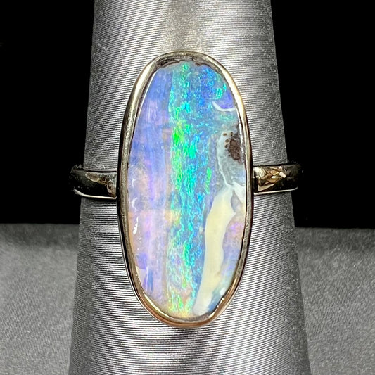 Ladies' yellow gold solitaire ring bezel set with a natural green striped boulder opal from Quilpie, Australia.