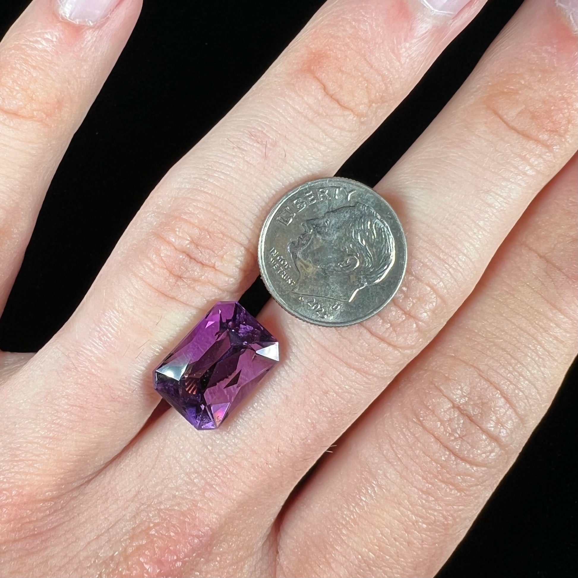 A loose, modified radiant cut amethyst stone.