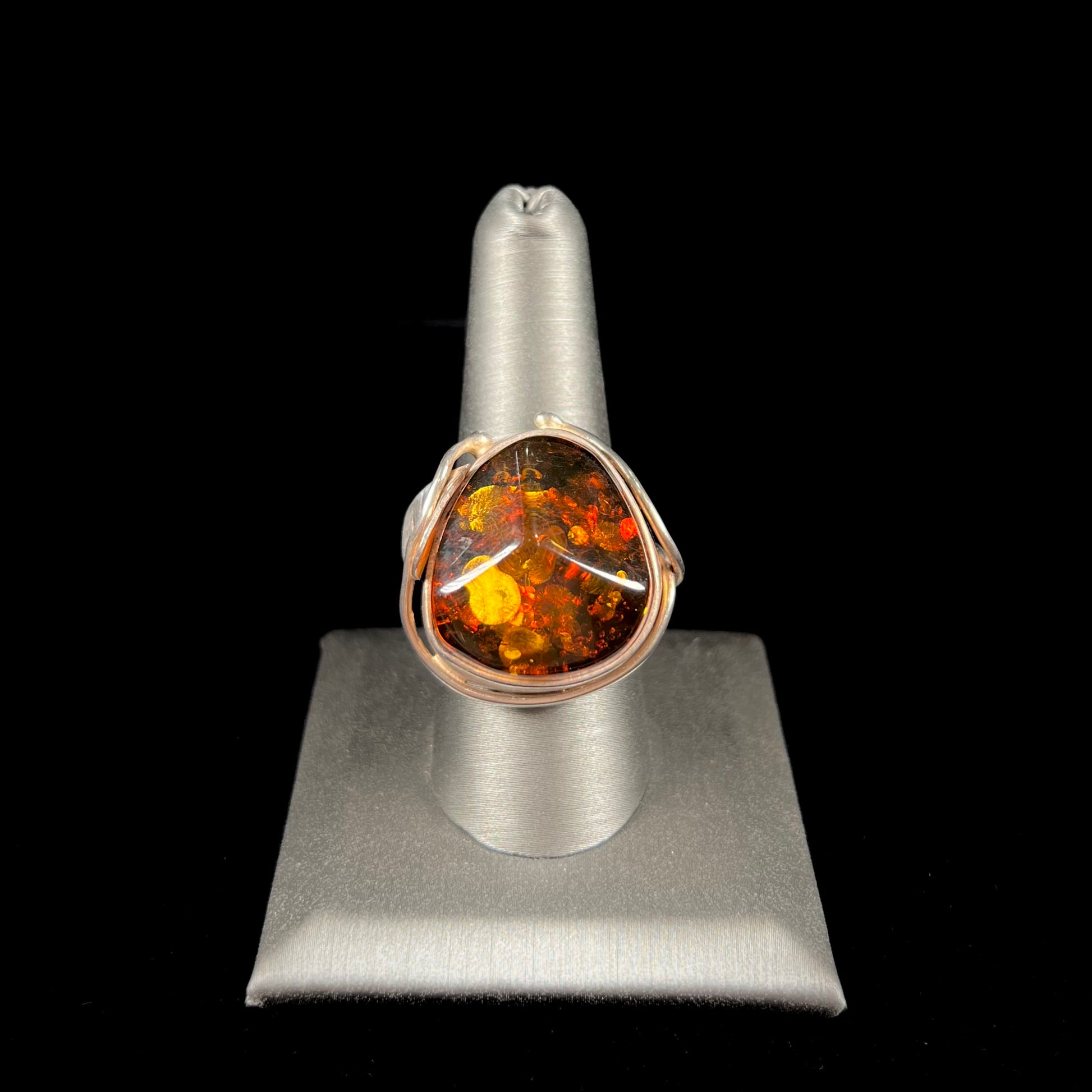 Unisex sterling silver ring set with a large sun-spangled Baltic amber gemstone.