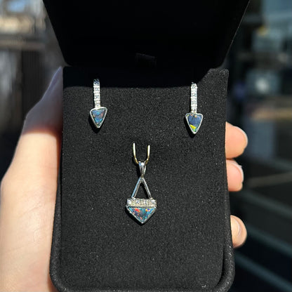 A white gold pendant and earrings set mounted with triangle cut natural black opals and diamonds.