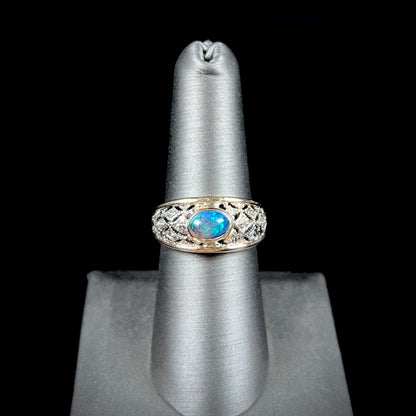 A ladies' yellow gold filigree style ring set with a natural black opal and diamond accents.