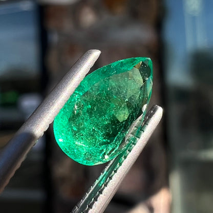 A loose, pear shaped natural emerald gemstone.