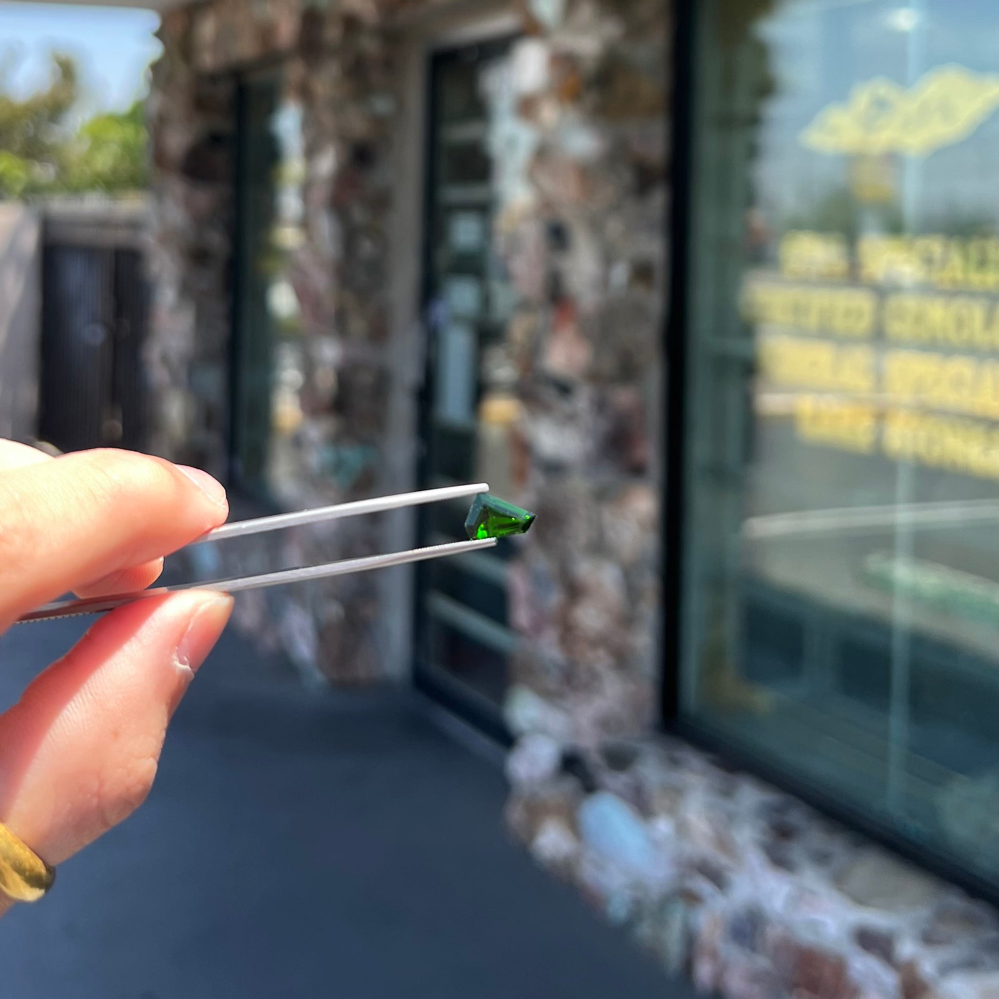 A freeform shield cut chrome diopside gemstone.