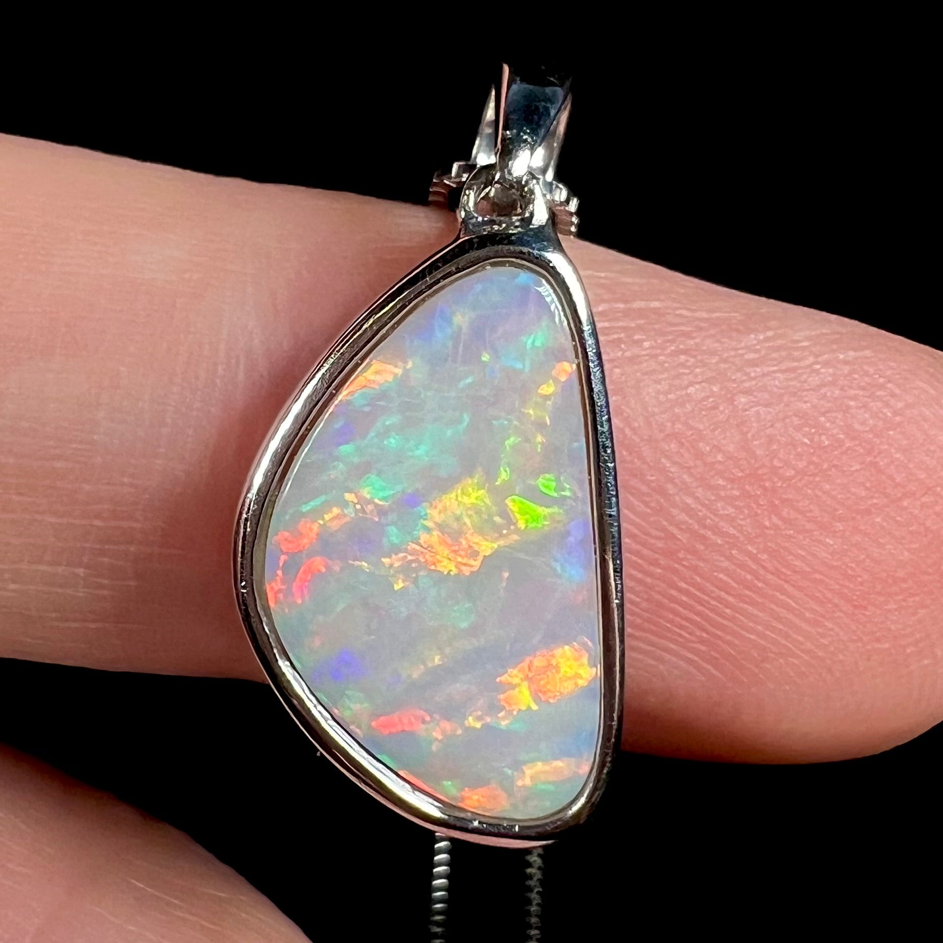 A sterling silver pendant bezel set with a white Australian crystal opal on a box chain.