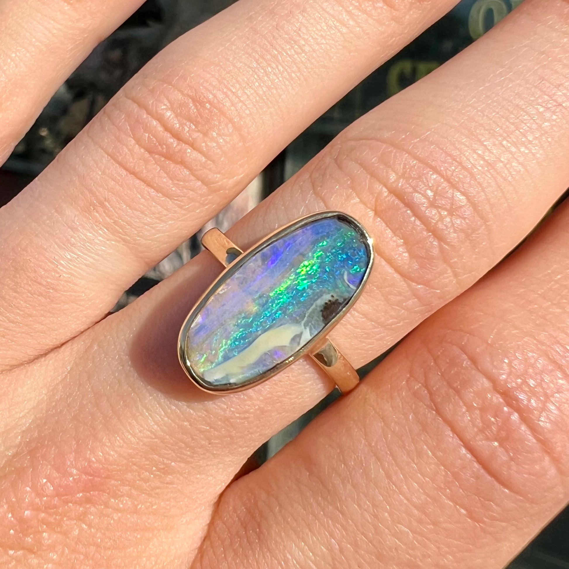 Ladies' yellow gold solitaire ring bezel set with a natural green striped boulder opal from Quilpie, Australia.