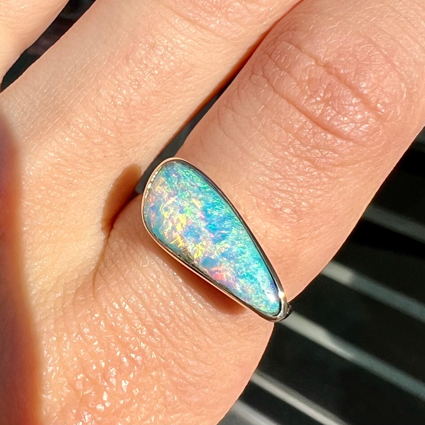 A ladies yellow gold solitaire ring bezel set with a natural opalized seashell from Coober Pedy, Australia.
