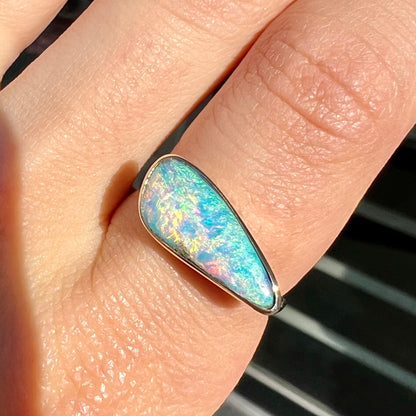 A ladies yellow gold solitaire ring bezel set with a natural opalized seashell from Coober Pedy, Australia.
