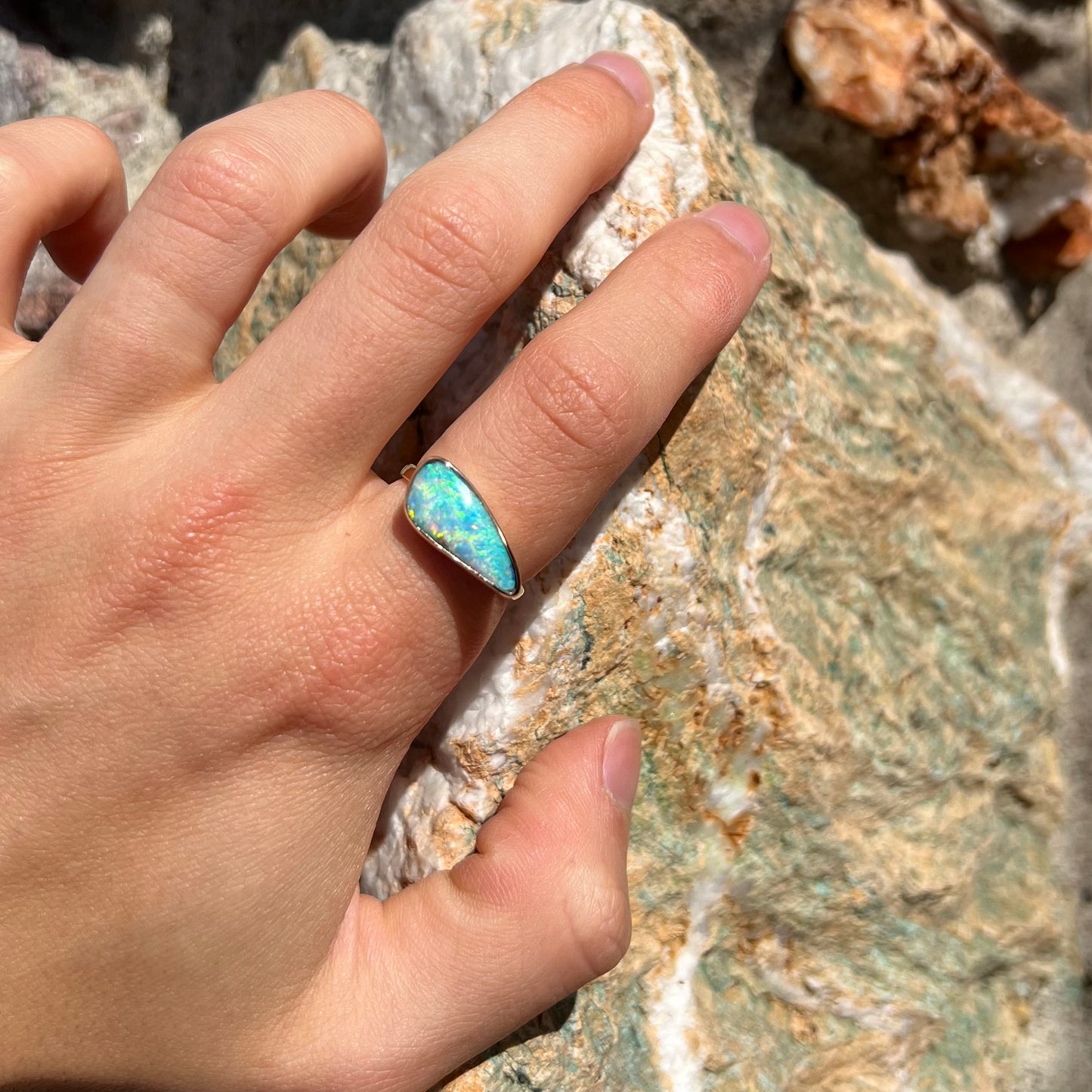 A ladies yellow gold solitaire ring bezel set with a natural opalized seashell from Coober Pedy, Australia.