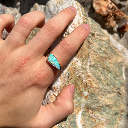 A ladies yellow gold solitaire ring bezel set with a natural opalized seashell from Coober Pedy, Australia.