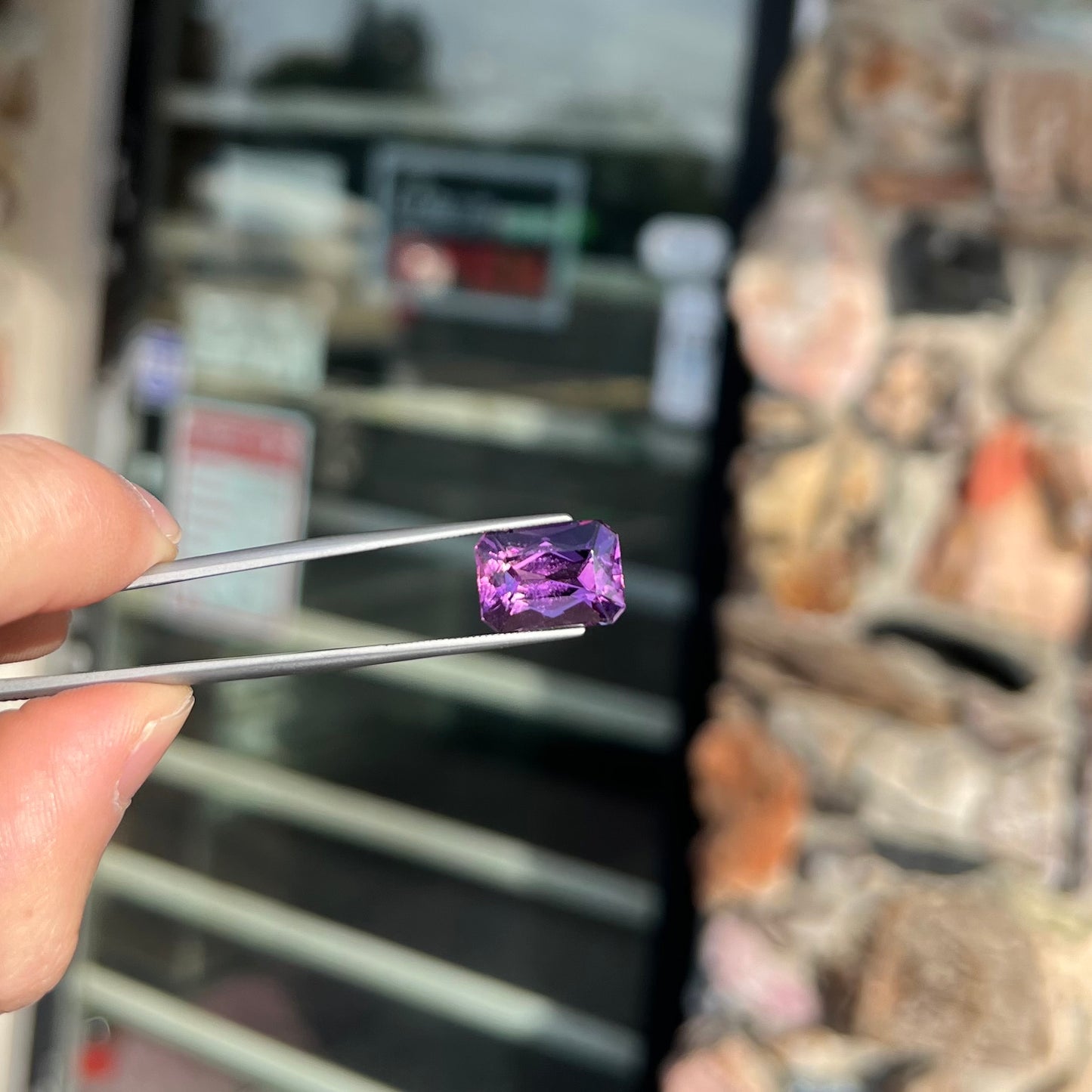 A loose, modified radiant cut amethyst stone.