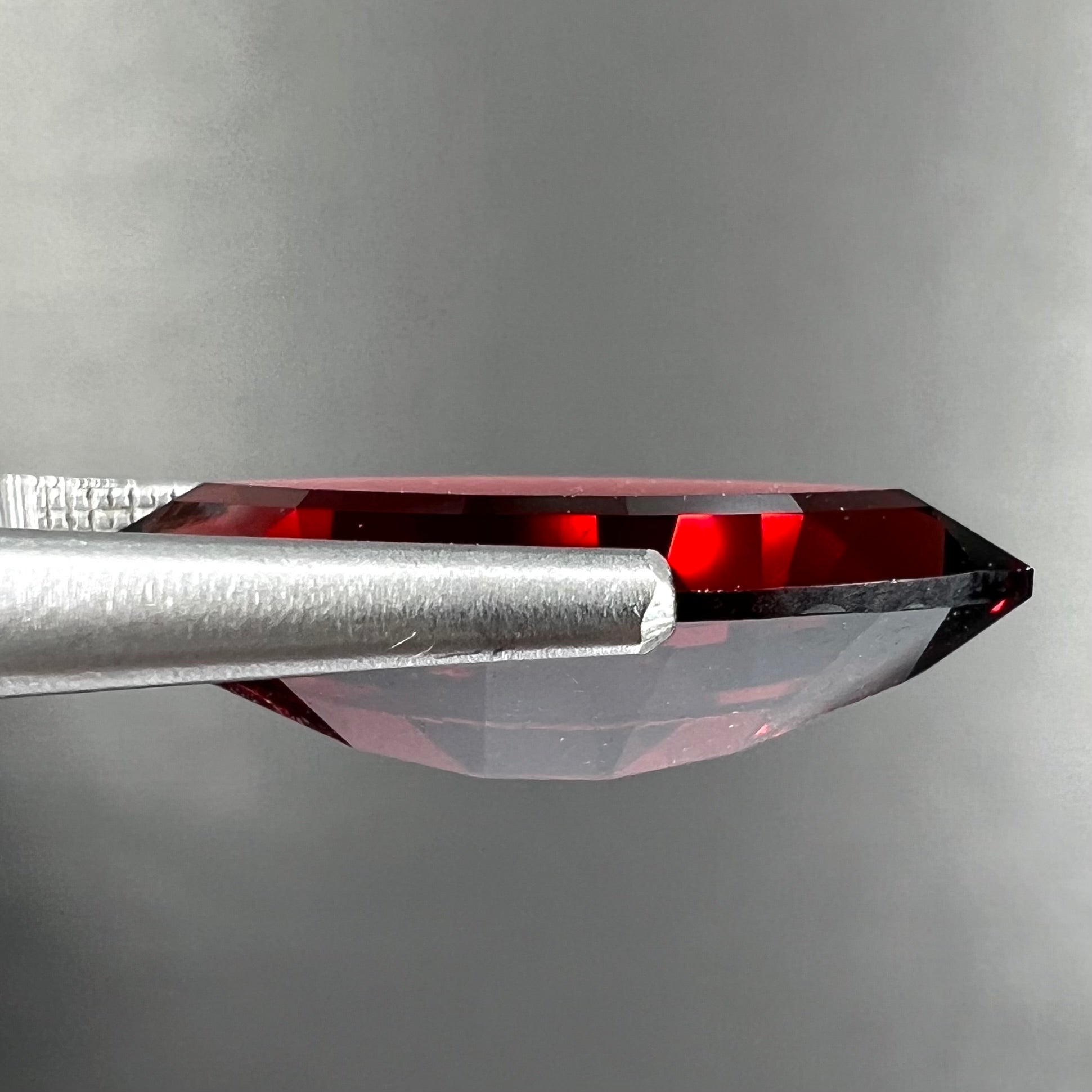 A faceted marquise cut red pyrope garnet stone.