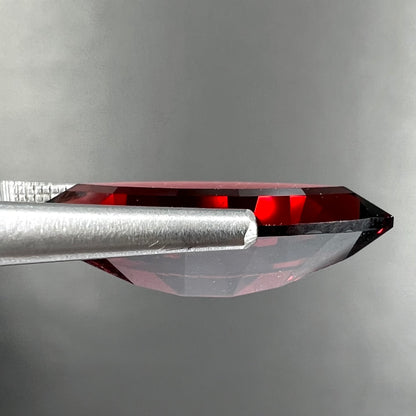 A faceted marquise cut red pyrope garnet stone.