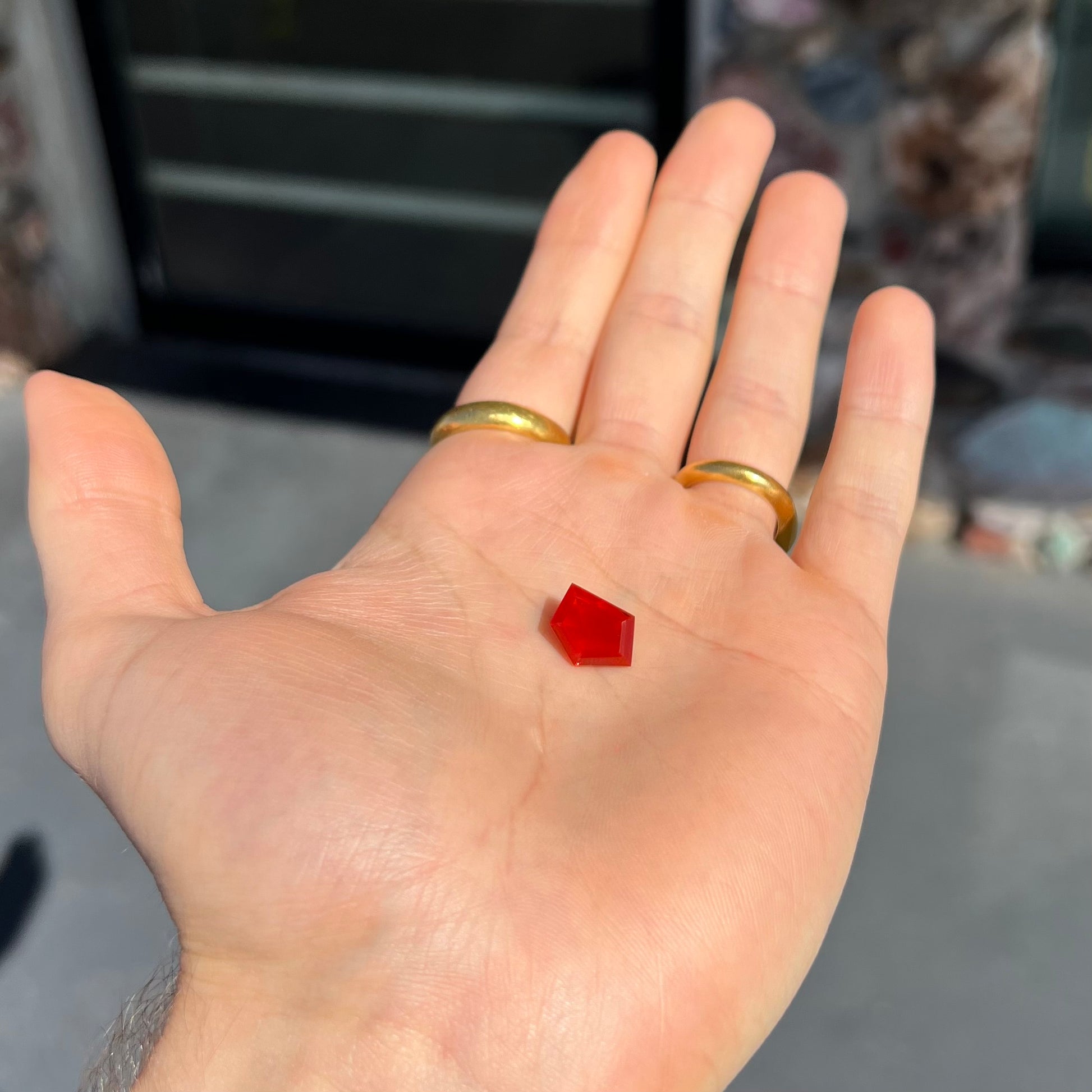 A loose, faceted freeform cut Mexican fire opal gemstone.  The stone is a cherry red color.