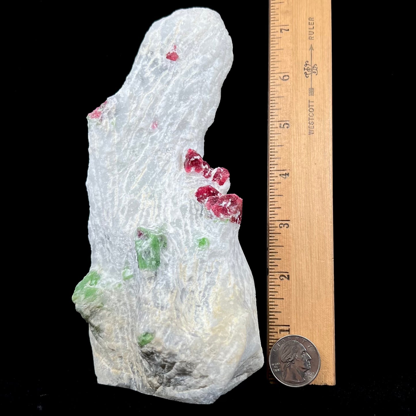 A white calcite specimen embedded with red spinel and green pargasite crystals from Luc Yen District, Vietnam.