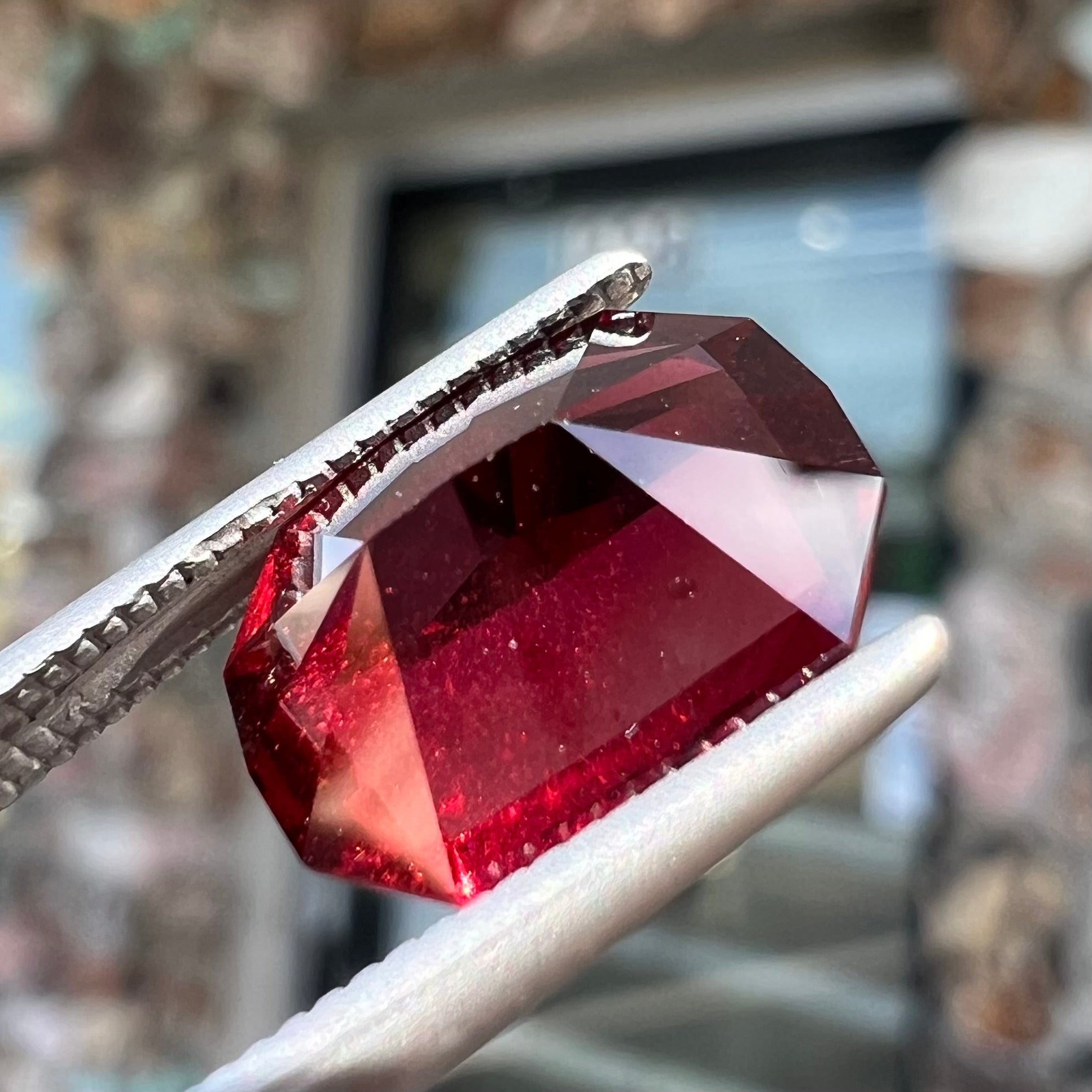 A loose, octagon cut rhodolite garnet gemstone.  The stone is a deep, purplish crimson red color.