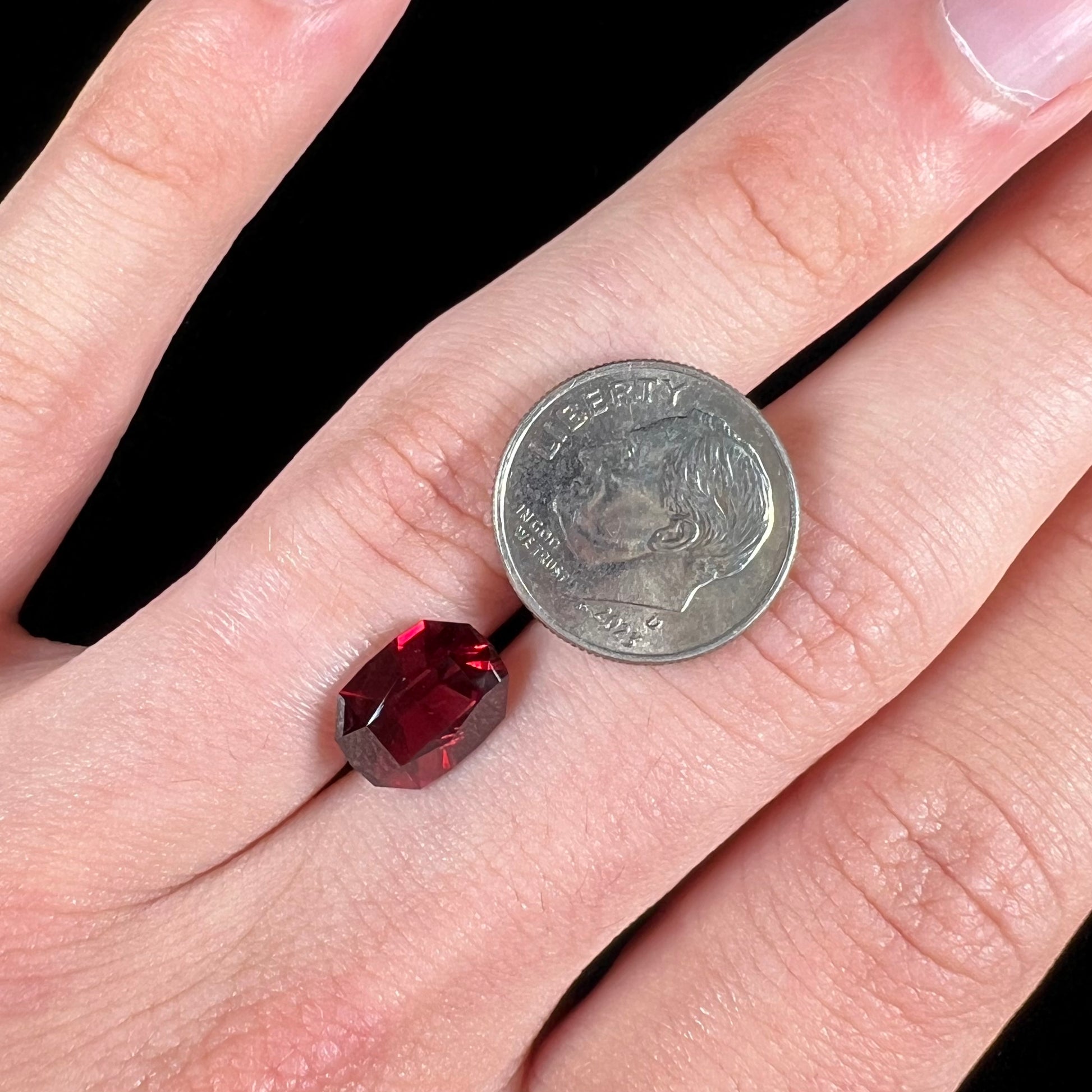 A loose, octagon cut rhodolite garnet gemstone.  The stone is a deep, purplish crimson red color.