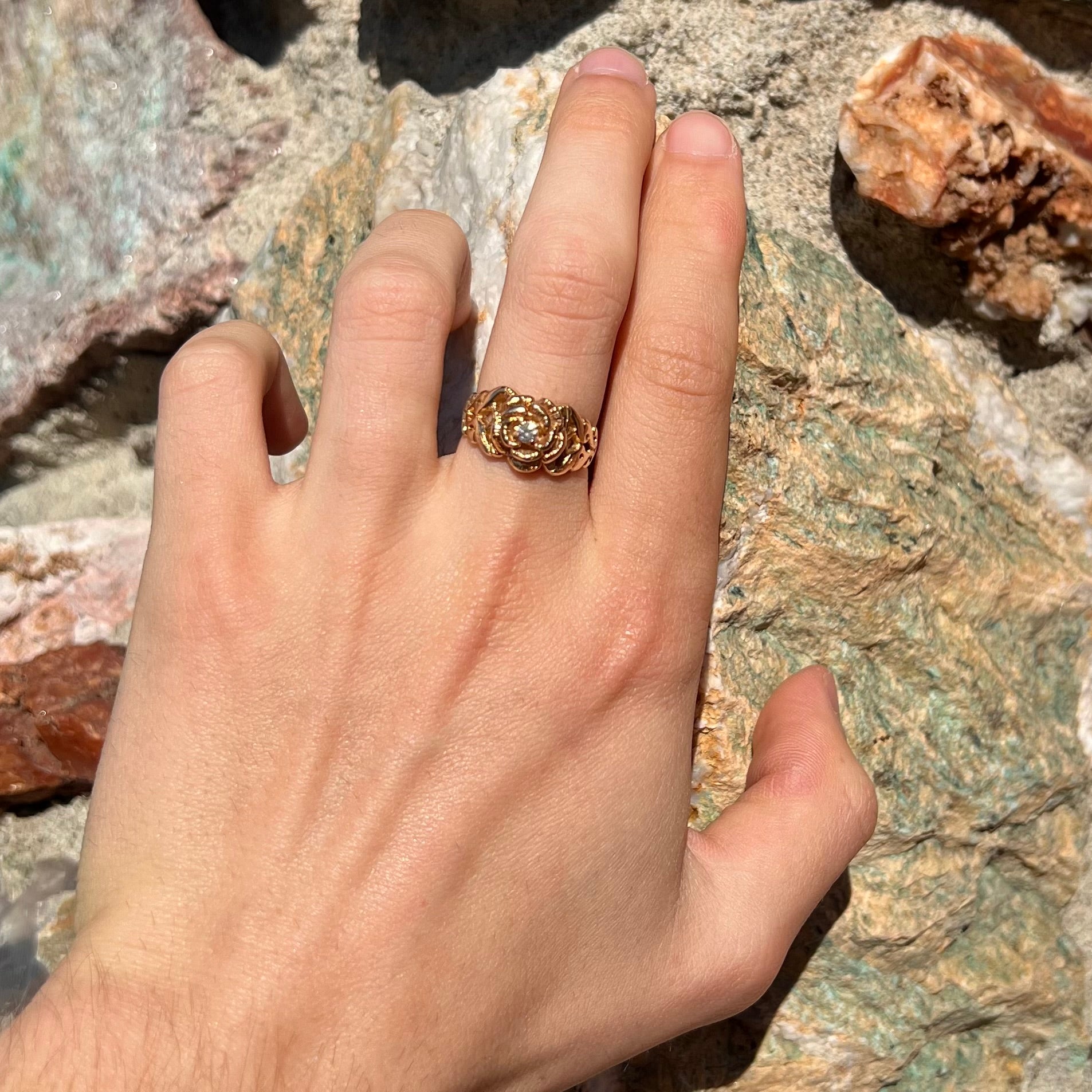 A ladies' yellow gold rose style ring set with a natural 0.10ct diamond.