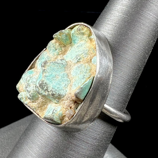 A handmade unisex sterling silver solitaire ring set with a rough, unpolished piece of turquoise stone.