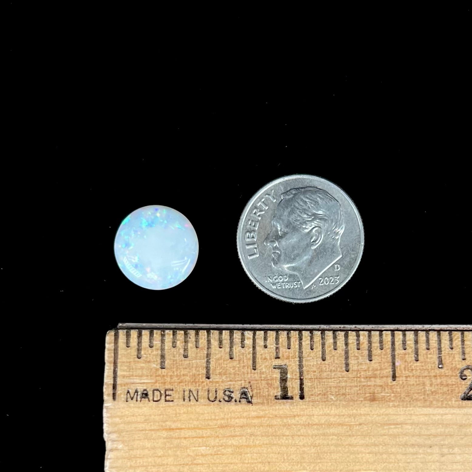 A loose, round cabochon cut white opal from Coober Pedy, Australia.  The opal has green fire.