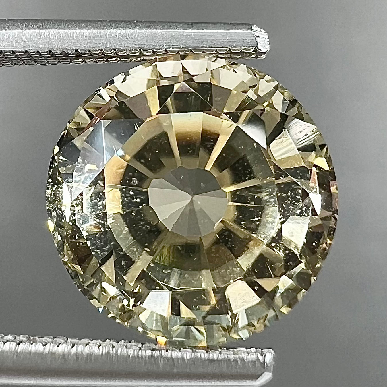 A loose, round brilliant cut citrine gemstone.  The stone is light yellow color.