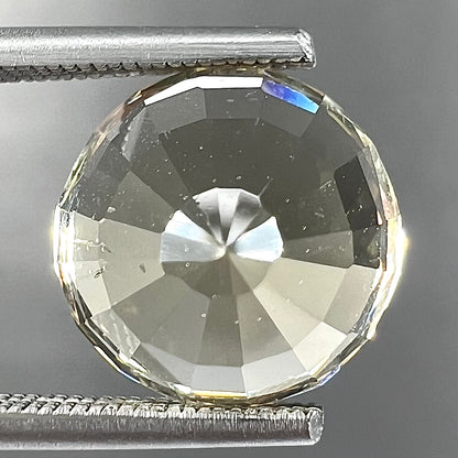 A loose, round brilliant cut citrine gemstone.  The stone is light yellow color.