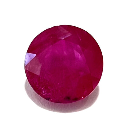 A faceted round brilliant cut Burma ruby gemstone.  The stone is certified as natural by Guild Laboratories.