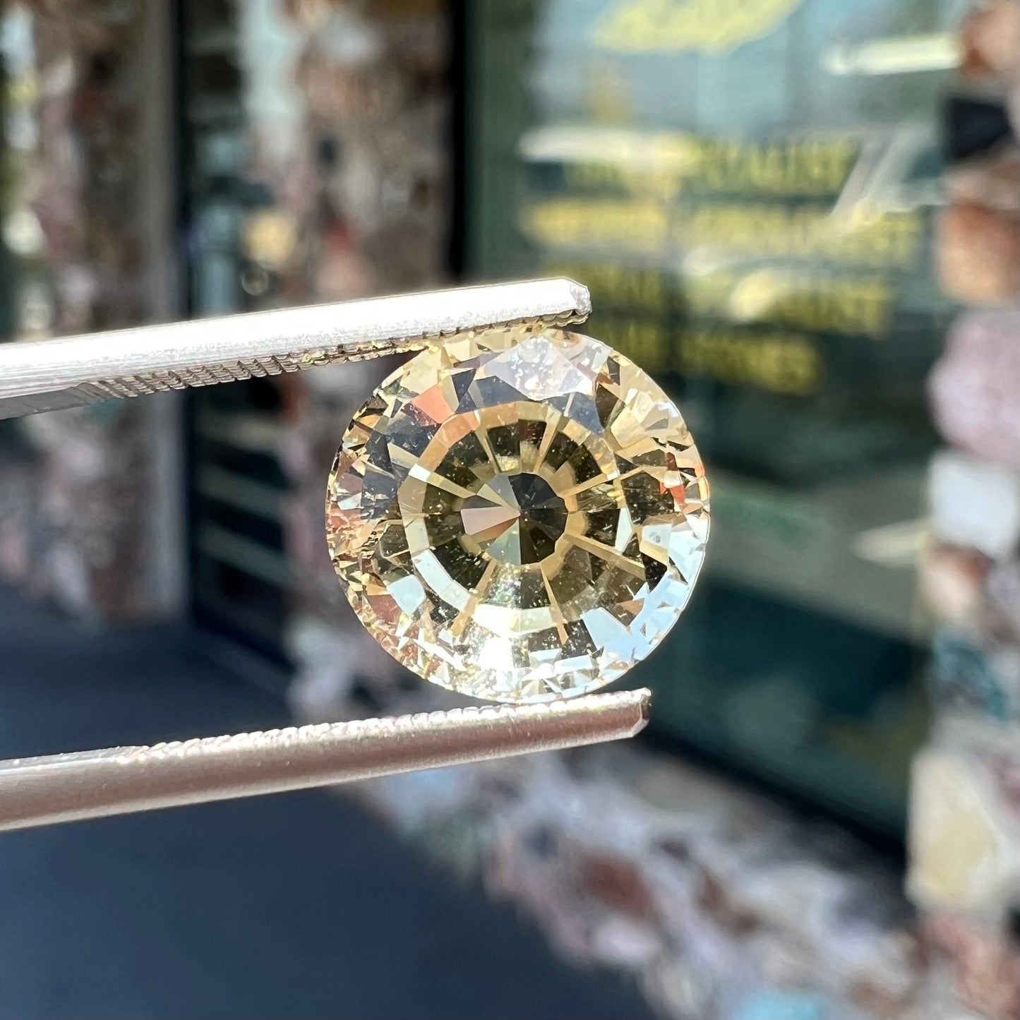 A loose, round brilliant cut citrine gemstone.  The stone is light yellow color.
