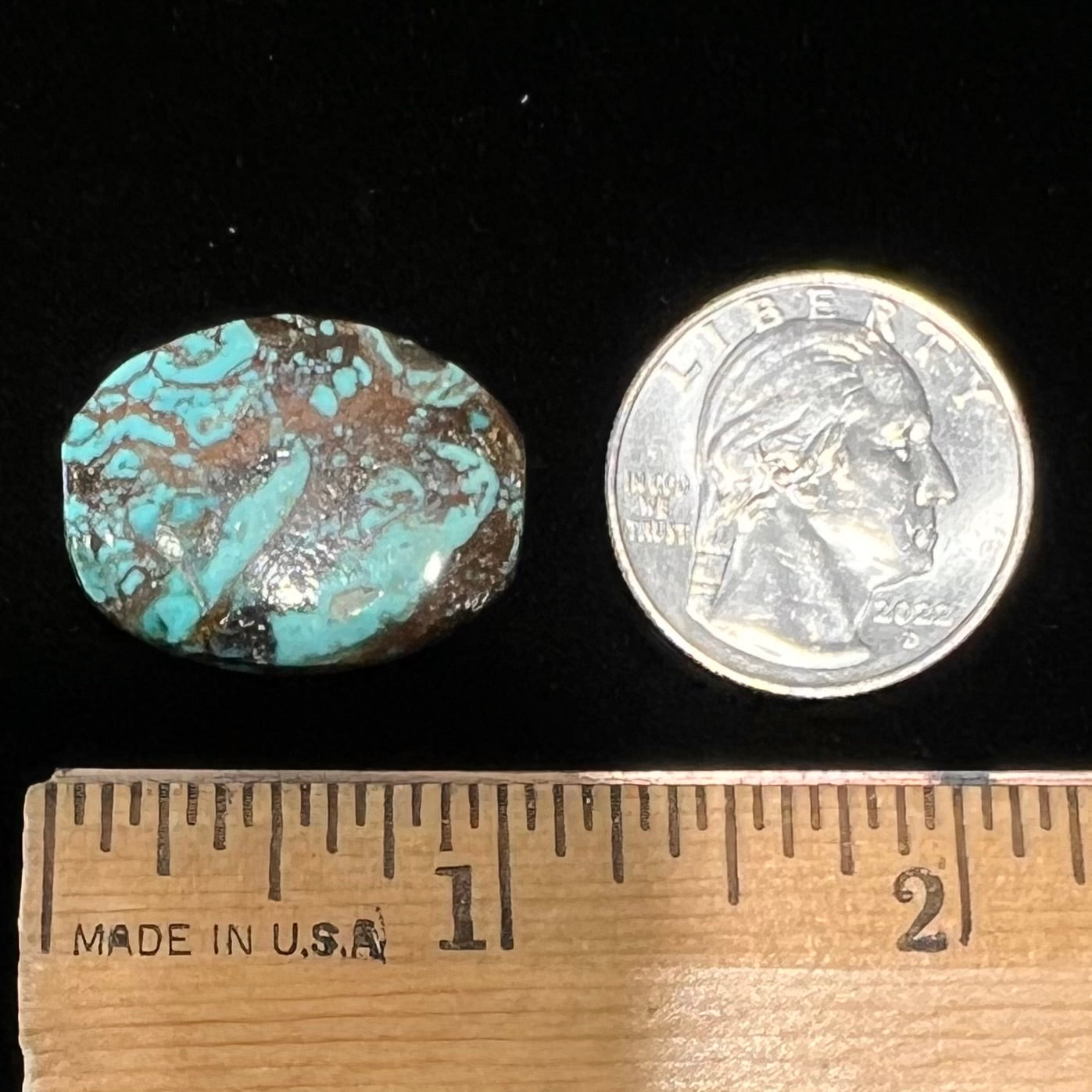 A loose, barrel cabochon cut turquoise stone from Royston District, Nevada.  The stone is greenish blue with brown and black matrix.