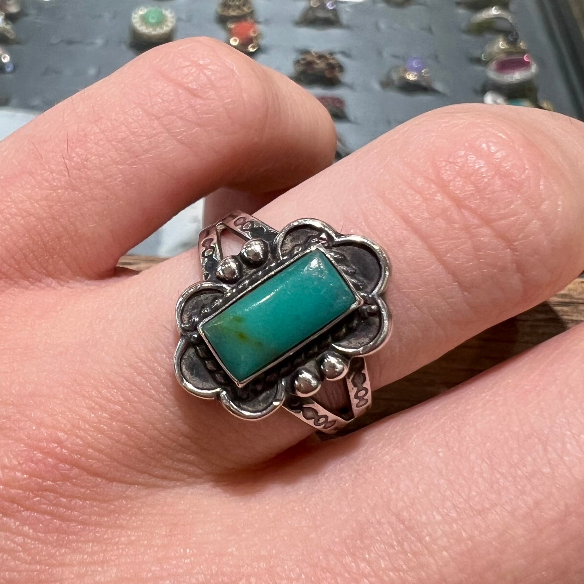 A ladies' silver ring stamped with Southwest style designs and set with a rectangular cabochon cut Royston turquoise stone.