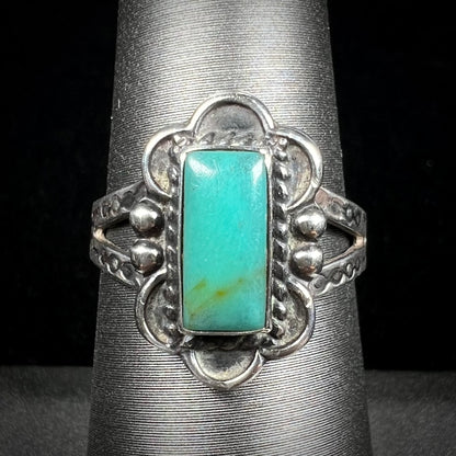A ladies' silver ring stamped with Southwest style designs and set with a rectangular cabochon cut Royston turquoise stone.