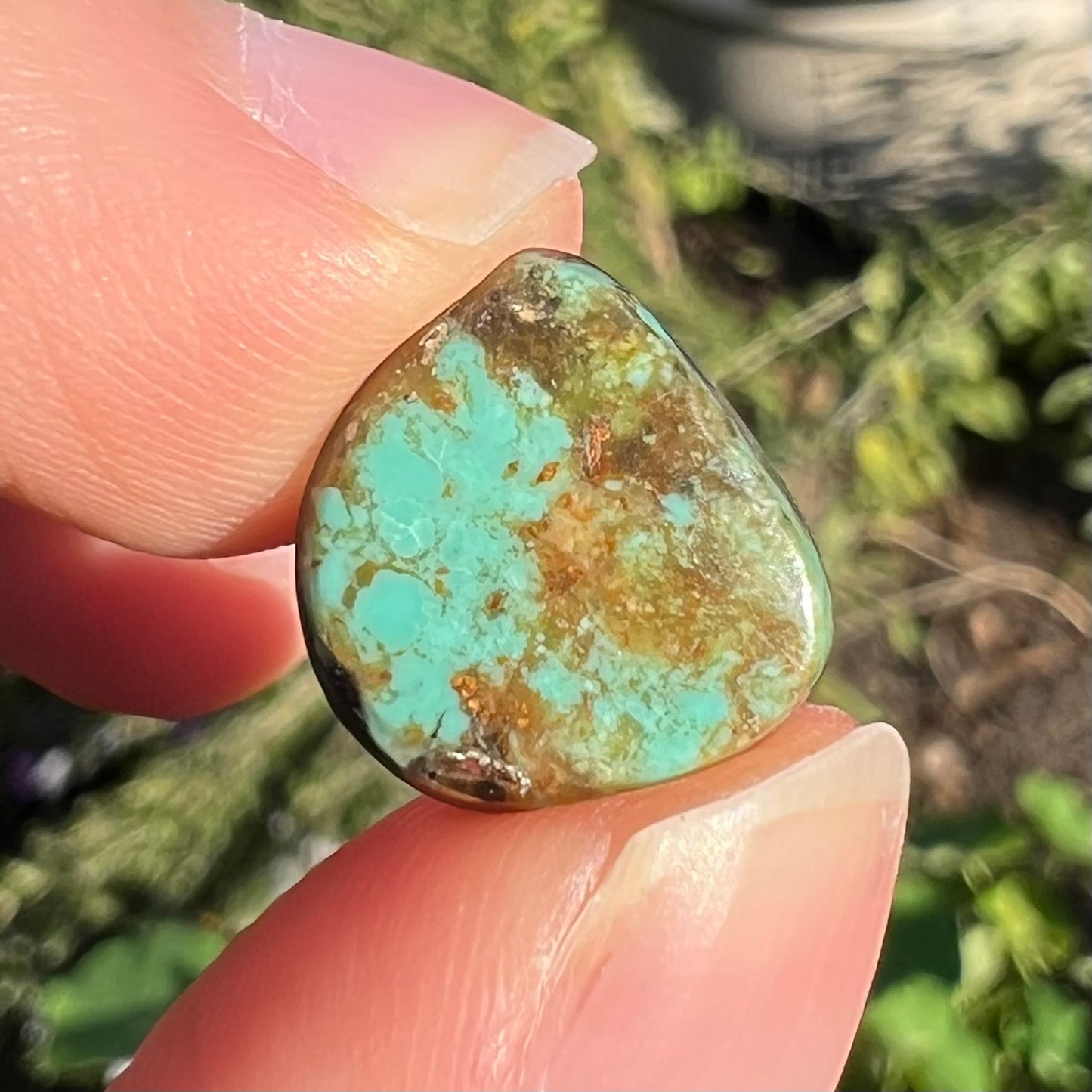 A loose, freeform cabochon cut Royston turquoise stone.