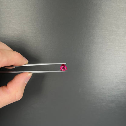 A loose, trillion cut rubellite tourmaline gemstone.