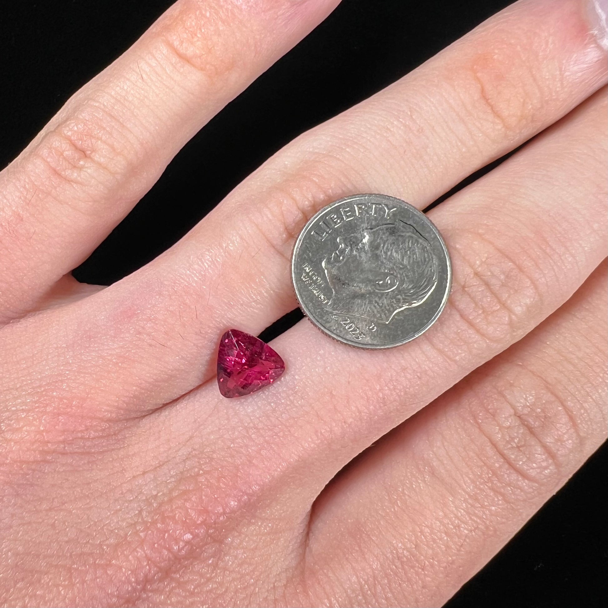A loose, trillion cut rubellite tourmaline gemstone.